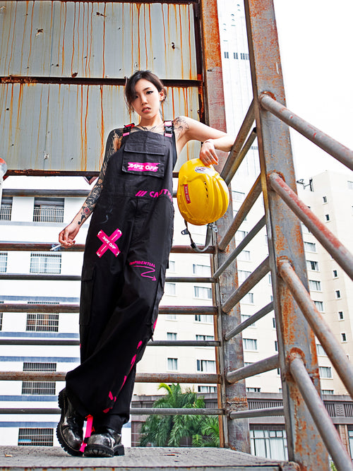 Dark Grey Overalls by TAPE OFF, featuring utility-inspired design, cuffed pant legs, neon pink stitching, and modern workwear-inspired style. Unisex streetwear overalls for industrial fashion and urban looks.