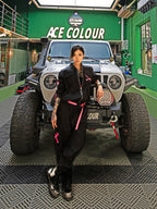 Dark Grey Jumpsuit featuring bomber jacket style, cuffed pants, chunky zipper, and neon accent lining. Perfect for streetwear, industrial fashion, and urban style trends.