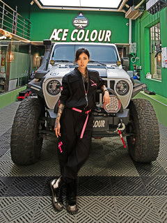 Dark Grey Jumpsuit featuring bomber jacket style, cuffed pants, chunky zipper, and neon accent lining. Perfect for streetwear, industrial fashion, and urban style trends.