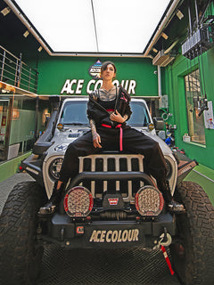 Dark Grey Jumpsuit featuring bomber jacket style, cuffed pants, chunky zipper, and neon accent lining. Perfect for streetwear, industrial fashion, and urban style trends.