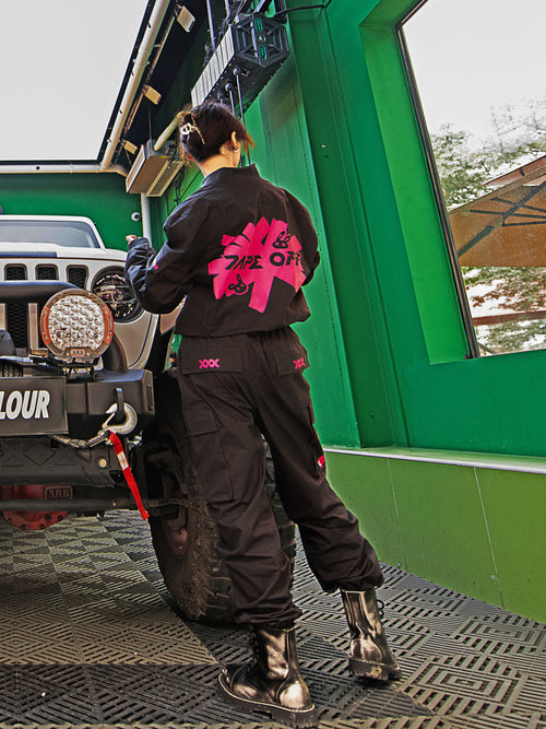 Dark Grey Jumpsuit featuring bomber jacket style, cuffed pants, chunky zipper, and neon accent lining. Perfect for streetwear, industrial fashion, and urban style trends.