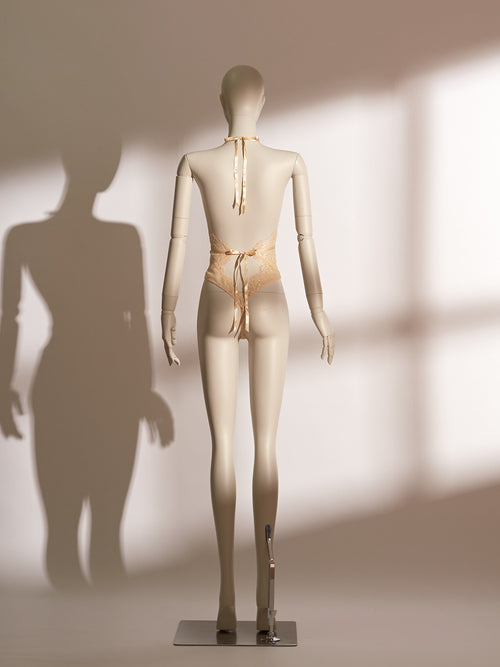 model wearing golden sheer lace bodysuit