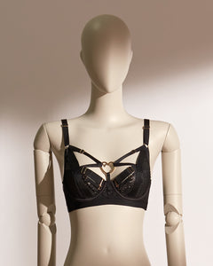 Heartbound Wire Bra Set in black eyelash lace and jacquard mesh, featuring a structured underwire bra with strappy detailing and a central heart-shaped hardware accent. Paired with a matching thong showcasing a wide waistband and heart embellishment, this seductive lingerie set from the Pills N Poison collection blends romantic flair with bold support.