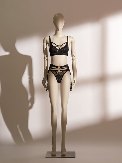 Heartbound lingerie set featuring a black underwire bra with wide straps, heart-shaped hardware, and mesh paneling, paired with a matching thong and a high-waisted lace garter belt with coordinating heart accents and adjustable suspenders. A chic and seductive three-piece set from Pills N Poison, combining comfort, support, and flirtatious detailing.