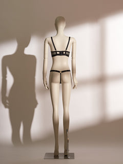 Heartbound Wire Bra Set in black eyelash lace and jacquard mesh, featuring a structured underwire bra with strappy detailing and a central heart-shaped hardware accent. Paired with a matching thong showcasing a wide waistband and heart embellishment, this seductive lingerie set from the Pills N Poison collection blends romantic flair with bold support.