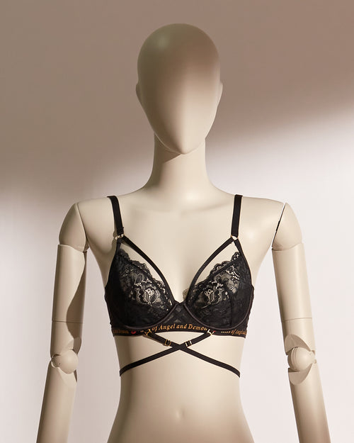 Infernal Grace Underwire Bra Set in black lace, featuring a full-cup design with intricate floral lace, supportive underwire, and adjustable strappy accents that wrap elegantly around the waist. Paired with a matching lace thong, this seductive lingerie set from the Pills N Poison collection combines timeless sophistication with versatile styling.