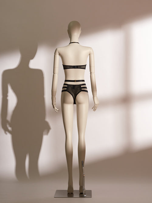 Black lace Isadora Halter Bra Set on mannequin, featuring wide halter straps, underwire bra with front clasp, high-waisted thong with strappy harness design and gold-tone hardware, styled for seductive elegance.