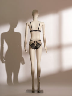 Midnight Allure Bralette Set in sheer black mesh and floral lace, featuring a wireless triangle bralette with wide straps and a secure hook-and-eye closure, paired with a matching low-rise thong detailed with cross-over elastic straps and delicate lace front panel. A chic and seductive lingerie design from Pills N Poison.