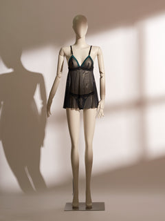 Nocturne Tassel Babydoll featuring sheer black mesh with emerald satin-trimmed triangle cups, tassel accents, and a flared skirt silhouette for a playful yet elegant lingerie look.