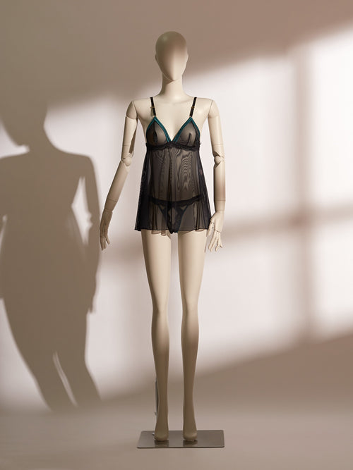 Nocturne Tassel Babydoll featuring sheer black mesh with emerald satin-trimmed triangle cups, tassel accents, and a flared skirt silhouette for a playful yet elegant lingerie look.