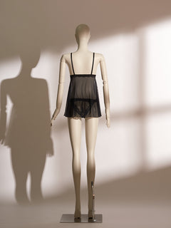 Nocturne Tassel Babydoll featuring sheer black mesh with emerald satin-trimmed triangle cups, tassel accents, and a flared skirt silhouette for a playful yet elegant lingerie look.