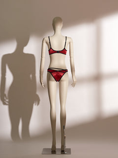 Red underwire bra and matching thong lingerie set with black trim and double straps, featuring a sheer fabric finish and asymmetric waistband, designed for petite body types.