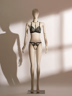 Close-up of the Emerald Obsidian Embroidery Ouvert Knicker featuring black satin straps, delicate green lace embroidery, and a bold open crotch design on a mannequin.