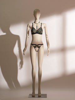 Close-up of the Emerald Obsidian Embroidery Ouvert Knicker featuring black satin straps, delicate green lace embroidery, and a bold open crotch design on a mannequin.
