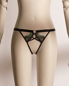 Close-up of the Emerald Obsidian Embroidery Ouvert Knicker featuring black satin straps, delicate green lace embroidery, and a bold open crotch design on a mannequin.